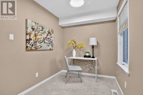 Ottawa townhouse for rent - A room with a painting on the wall and a table with a lamp and plant.