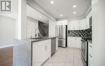 Milton (Dp Dorset Park) townhouse for rent - A modern kitchen with white cabinets and stainless steel appliances.