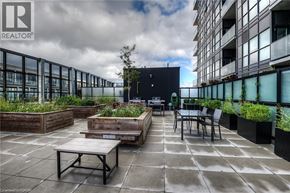 Kitchener condo for rent - A patio with a table and chairs is surrounded by planters.