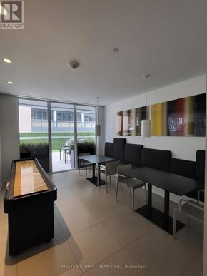 Toronto (Church-Yonge Corridor) condo for rent - A billiard table is in the middle of a room with a black couch and a white wall.