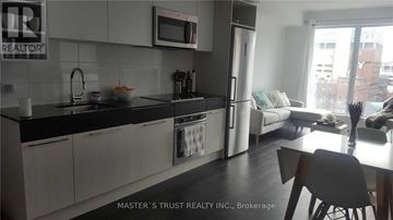 Toronto (Church-Yonge Corridor) condo for rent - A kitchen with a dining table and chairs in the foreground and a couch in the background.