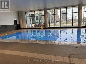 Markham (Unionville) condo for rent - A large indoor swimming pool with a tiled floor and a glass wall overlooking the outside.