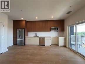 Lasalle townhouse for rent - A large, empty kitchen with wooden cabinets and a refrigerator.