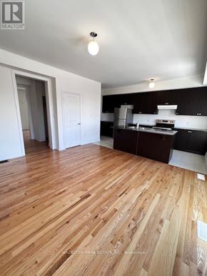 Whitby (Port Whitby) townhouse for rent - A kitchen with wooden floors and white walls.