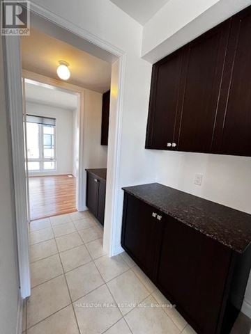 Whitby (Port Whitby) townhouse for rent - A kitchen with brown cabinets and a white wall.