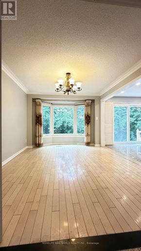 Markham (Unionville) apartment for rent - A spacious room with wooden flooring and a chandelier.