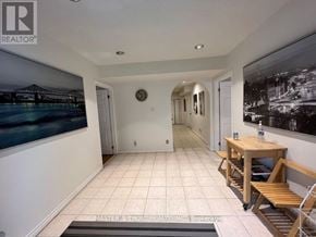 Toronto (Hillcrest Village) apartment for rent - A hallway with a clock on the wall and a bench with a table.