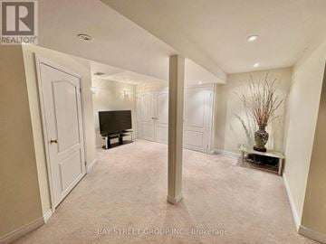 Markham (Berczy) apartment for rent - A living room with a television and a vase with branches in it.