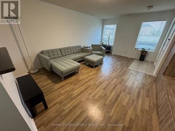Markham (Milliken Mills East) townhouse for rent - A living room with a grey couch and wooden flooring.