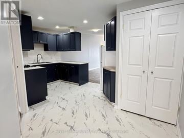 Guelph (Downtown) multi-family for rent - A kitchen with black cabinets and marble flooring.