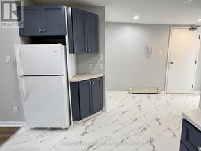 Guelph (Downtown) multi-family for rent - A white refrigerator is in a kitchen with marble flooring.