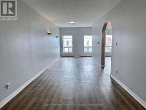 Guelph (Downtown) multi-family for rent - A spacious room with wooden flooring and white walls.