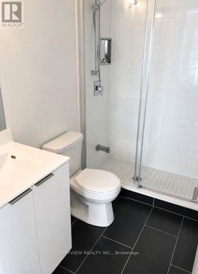 Toronto (Mimico) condo for rent - A white toilet in a bathroom with a glass shower door.