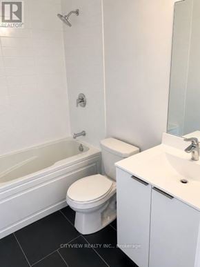 Toronto (Mimico) condo for rent - A white toilet sits next to a white sink in a bathroom.