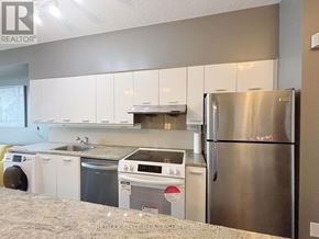 Toronto (Bayview Village) condo for rent - A kitchen with a stainless steel refrigerator and white cabinets.