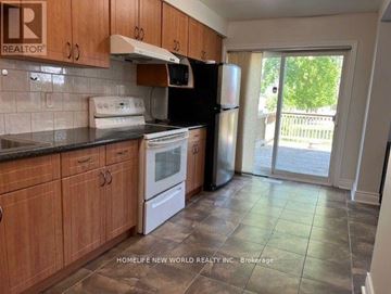 Markham (Milliken Mills East) apartment for rent - A kitchen with wooden cabinets and a black refrigerator.