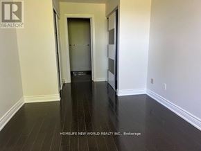 Markham (Milliken Mills East) apartment for rent - A hallway with a door and a refrigerator in the background.