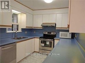 Toronto (Willowdale East) apartment for rent - A kitchen with white cabinets and a blue backsplash.