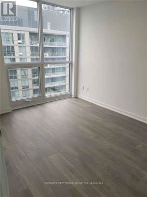 Toronto (Henry Farm) condo for rent - A room with a large window and a wooden floor.