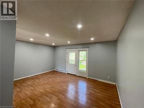 Woodstock townhouse for rent - A room with wooden flooring and a window with a view of greenery outside.