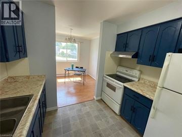 Woodstock townhouse for rent - A kitchen with blue cabinets and a white refrigerator.