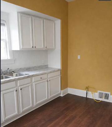 Cleveland apartment for rent - A kitchen with white cabinets and a yellow wall.
