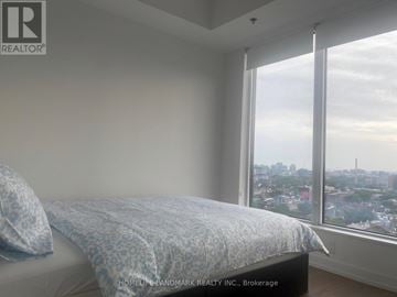 Toronto (Kensington-Chinatown) condo for rent - A bedroom with a bed and a window overlooking a cityscape.