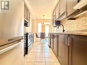 Newmarket (Woodland Hill) townhouse for rent - A kitchen with a tile floor and a refrigerator on the left.