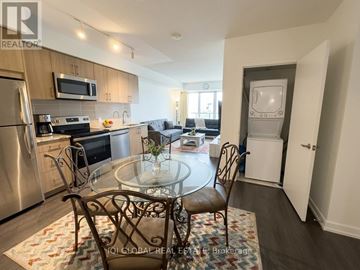 Toronto (Humber Heights) condo for rent - A kitchen with a glass table and chairs in the foreground and a refrigerator, microwave, oven, and sink in the background.