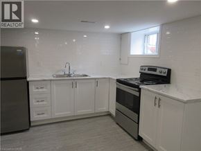 Hamilton apartment for rent - A kitchen with white cabinets and a black refrigerator.