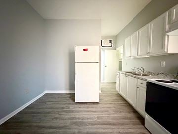 Louisville apartment for rent - A white refrigerator in a kitchen with wooden floors.