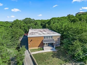 Dartmouth apartment for rent - A house with a grey roof is surrounded by green trees.