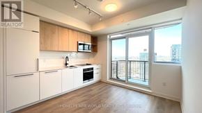 Toronto (Dovercourt-Wallace Emerson-Junction) condo for rent - A well-lit kitchen with white appliances and wooden cabinets.