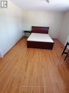 Toronto (L'amoreaux) apartment for rent - A bedroom with a bed, wooden floor, and a small table.