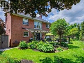 Markham (Unionville) apartment for rent - A red brick house with a green lawn and trees.