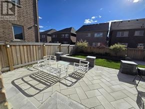 Bradford West Gwillimbury (Bradford) apartment for rent - A sunny backyard with a patio table and chairs.