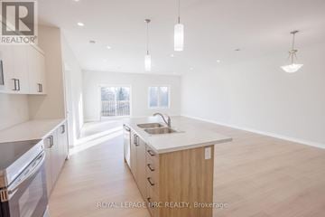 Thorold (Thorold Downtown) multi-family for rent - A modern kitchen with wooden cabinets and a large island.