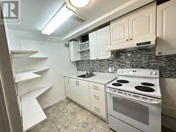 Toronto (Malvern) apartment for rent - A kitchen with white cabinets and a white stove top oven.