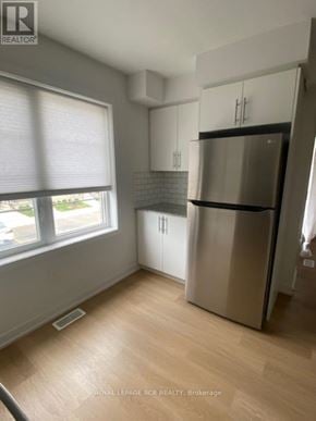 Kitchener townhouse for rent - A kitchen with a stainless steel refrigerator and wooden flooring.
