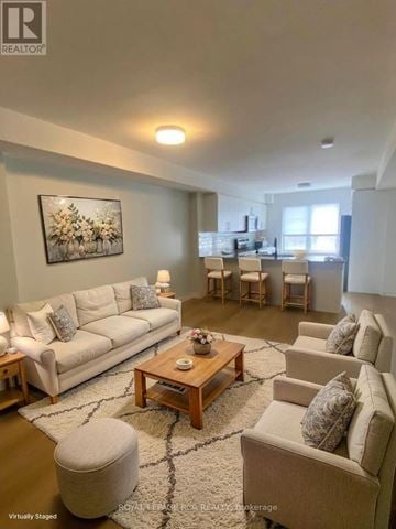 Kitchener townhouse for rent - A living room with a white couch, a coffee table, and a painting on the wall.