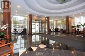 Toronto (Willowdale East) condo for rent - A large, well-lit lobby with a marble floor and wooden furniture.