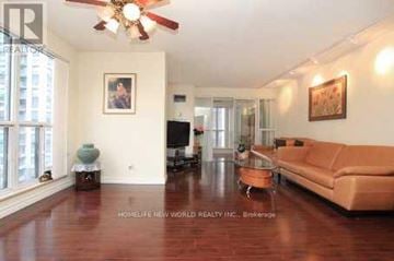 Toronto (Willowdale East) condo for rent - A living room with a brown couch and a ceiling fan.