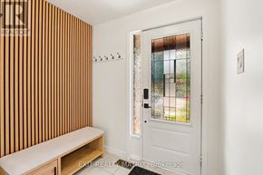 Ottawa apartment for rent - A white door with a glass window is in a room with a bench.