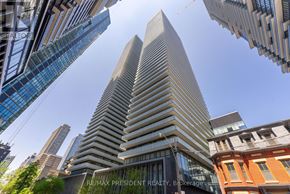 Toronto (Church-Yonge Corridor) condo for rent - A tall building with a glass facade stands in the foreground of a cityscape.