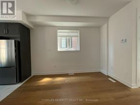 Barrie townhouse for rent - A room with wooden flooring and a window with blinds.
