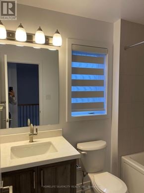 Barrie townhouse for rent - A bathroom with a sink, toilet and a window with blinds.
