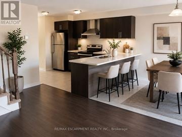 Brantford townhouse for rent - A modern kitchen with dark wood cabinets and white countertops.