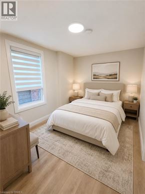 Hamilton apartment for rent - A bedroom with a large bed, a nightstand, and a window with blinds.