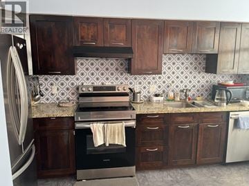 Richmond townhouse for rent - A kitchen with wooden cabinets and a tiled backsplash.