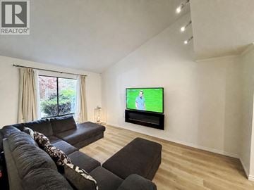 Richmond apartment for rent - A living room with a large couch and a flat screen TV mounted on the wall.